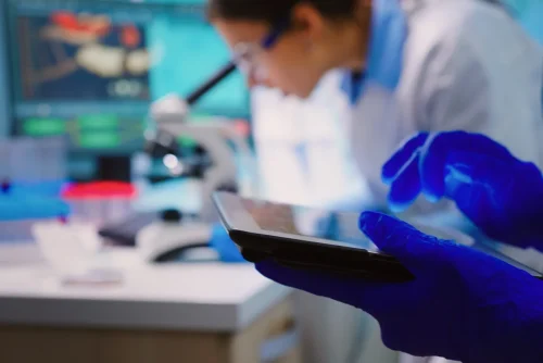 saac-citacoes-close-up-scientist-writing-tablet-while-team-biologists-doing-biological-researches-microscope-backgorund-late-night-scaled-1
